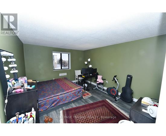 A bedroom with a bed, chair, and guitar.
