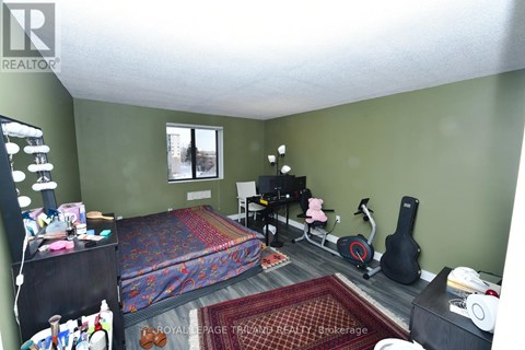 A bedroom with a bed, chair, and guitar.