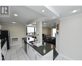 A kitchen with a black counter top and white cabinets.