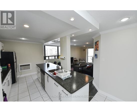 A kitchen with a black counter top and white cabinets.