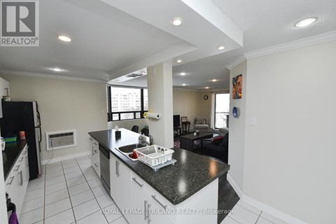 A kitchen with a black counter top and white cabinets.