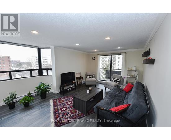 A living room with a black couch and a television.
