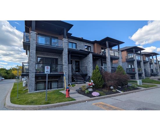 A modern apartment building with a no parking sign in front.