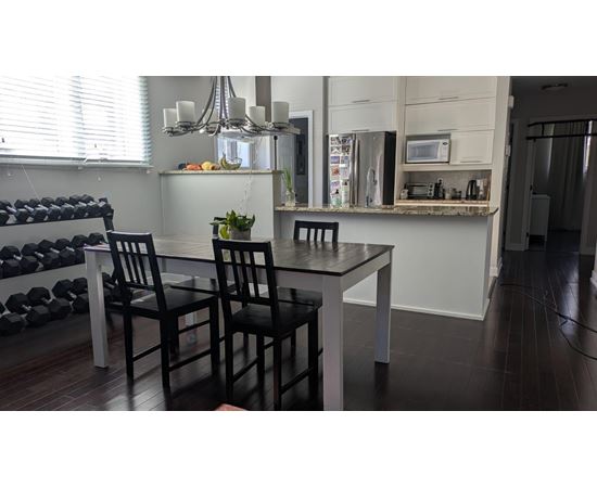 A black chair sits in front of a table in a kitchen.