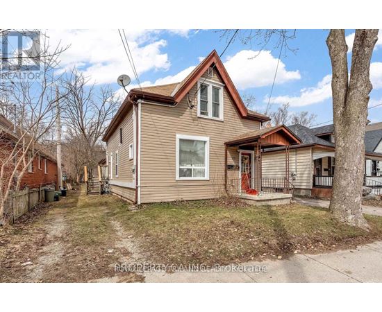 A house with a brown roof and a red door is for sale.