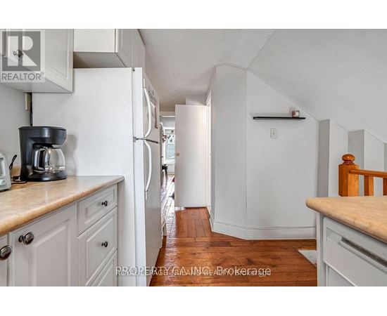 A kitchen with white cabinets and a white refrigerator.