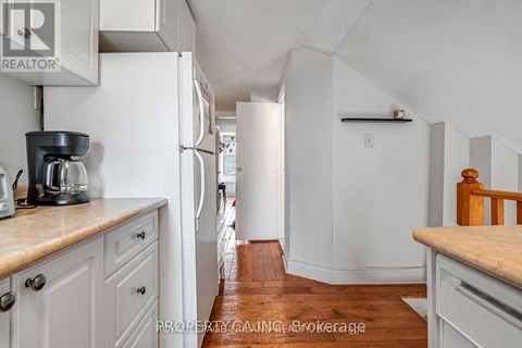 A kitchen with white cabinets and a white refrigerator.