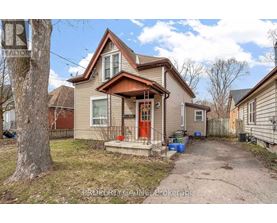 A house with a red door and a brown roof is for sale.
