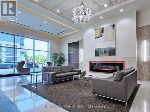 A living room with a grey sofa and a fireplace.
