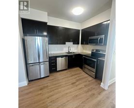 A kitchen with a refrigerator, oven, and microwave.