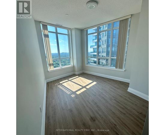 A room with a large window overlooking a cityscape.