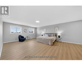 A bedroom with a bed, chair, and two wall decorations.