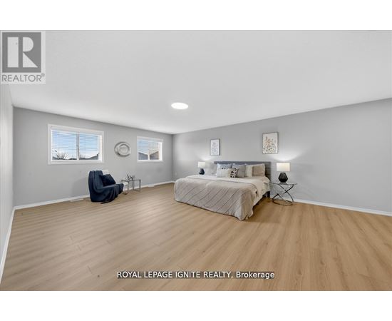 A bedroom with a bed, chair, and two wall decorations.