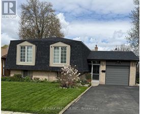 A house with a grey roof and a garage door is for sale.