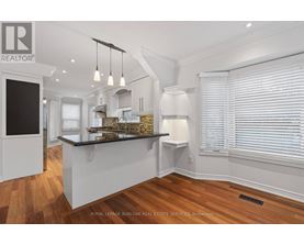A modern kitchen with white cabinets and a black countertop.
