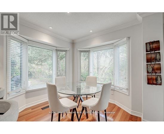 A dining room with a table and chairs.