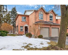 A large red brick house with a snow-covered front yard.