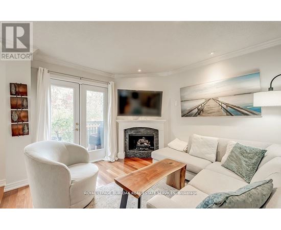 A living room with a fireplace and a painting on the wall.