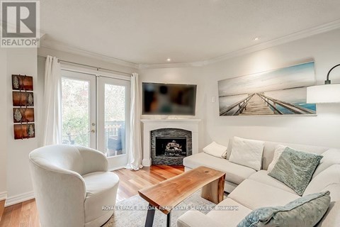 A living room with a fireplace and a painting on the wall.