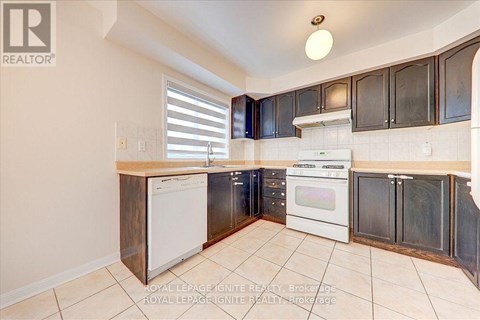A kitchen with white appliances and black cabinets.