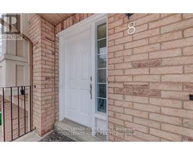 A white door is on the brick wall of a house.