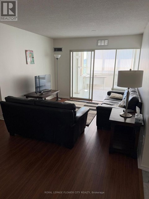 A living room with a black couch and a television.