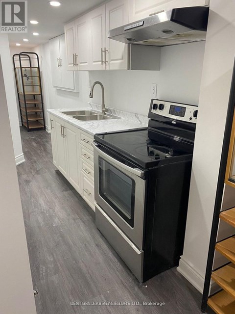 A modern kitchen with a black stove top oven.