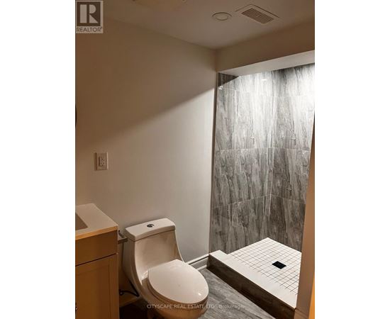 A bathroom with a toilet, sink, and shower.