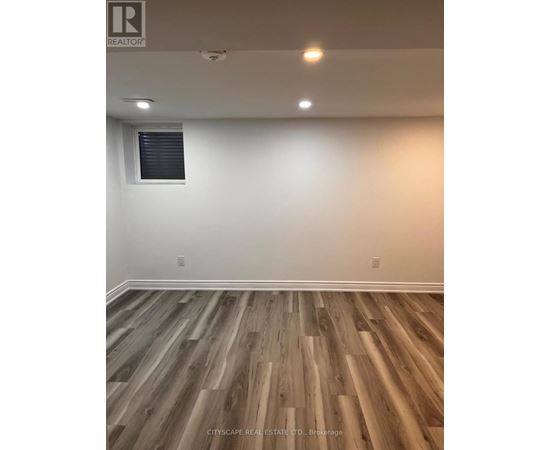 A room with wooden flooring and a window.