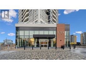 A modern building with a glass entrance and a brick pillar with the letters "SP" on it.