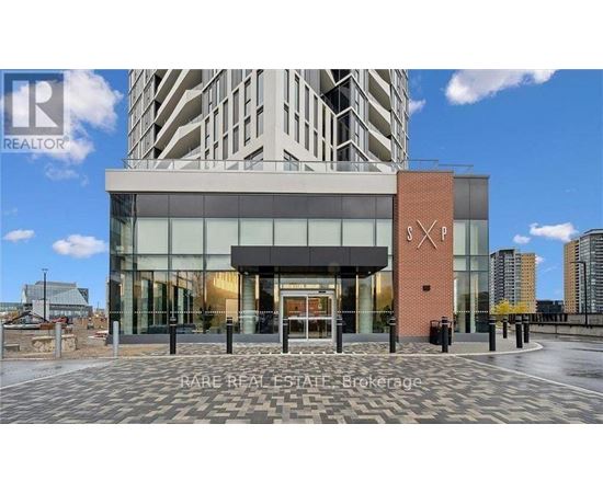 A modern building with a glass entrance and a brick pillar with the letters "SP" on it.
