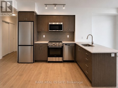 A modern kitchen with wooden cabinets and stainless steel appliances.