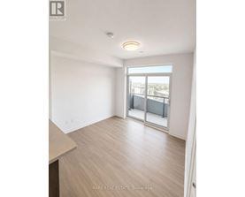A spacious room with a sliding glass door leading to a balcony.