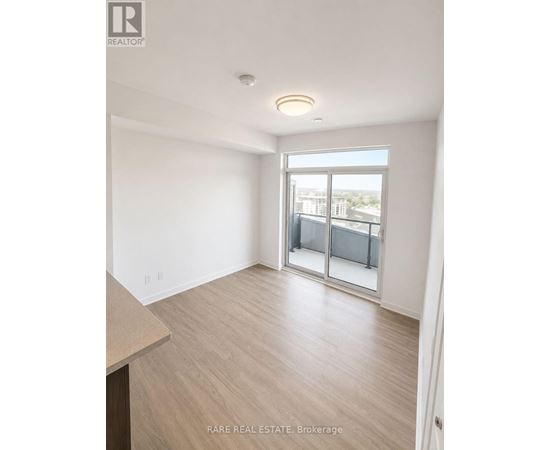 A spacious room with a sliding glass door leading to a balcony.