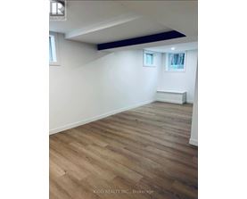 A room with wooden flooring and white walls.