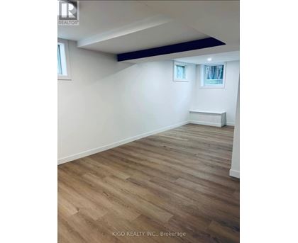 A room with wooden flooring and white walls.