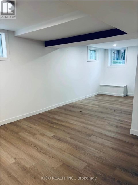A room with wooden flooring and white walls.