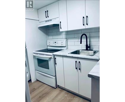 A white kitchen with a sink and a stove.