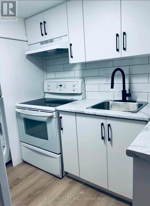 A white kitchen with a sink and a stove.