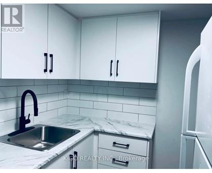 A kitchen with white cabinets and a marble countertop.