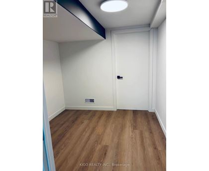 A room with a white door and a wooden floor.