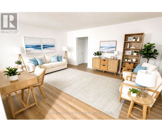 A living room with a white couch, a wooden table, and a painting of a beach scene on the wall.