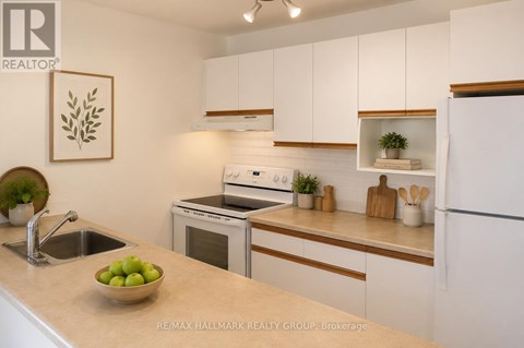 A kitchen with white cabinets and a bowl of green apples on the counter.