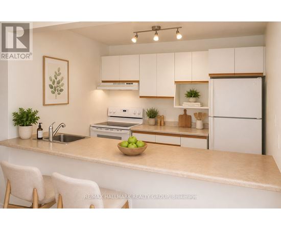 A kitchen with white cabinets and a countertop with a bowl of green apples on it.