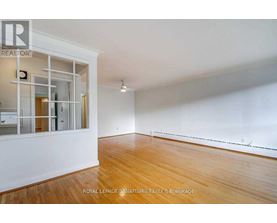 A spacious room with wooden floors and white walls.