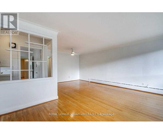 A spacious room with wooden floors and white walls.