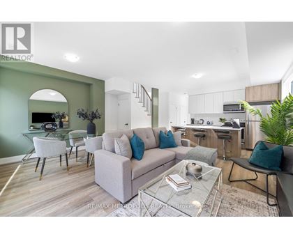 A modern living room with a glass coffee table and a grey sofa.
