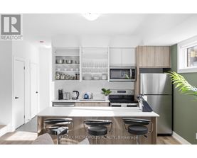 A modern kitchen with a white countertop and stainless steel appliances.
