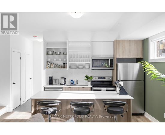 A modern kitchen with a white countertop and stainless steel appliances.