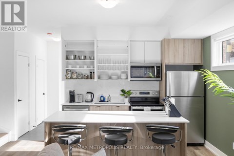 A modern kitchen with a white countertop and stainless steel appliances.